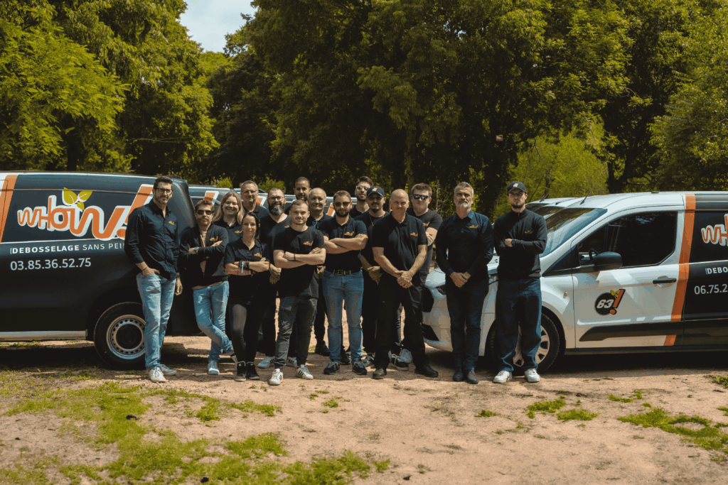Groupe de techniciens devant des véhicules de service en extérieur